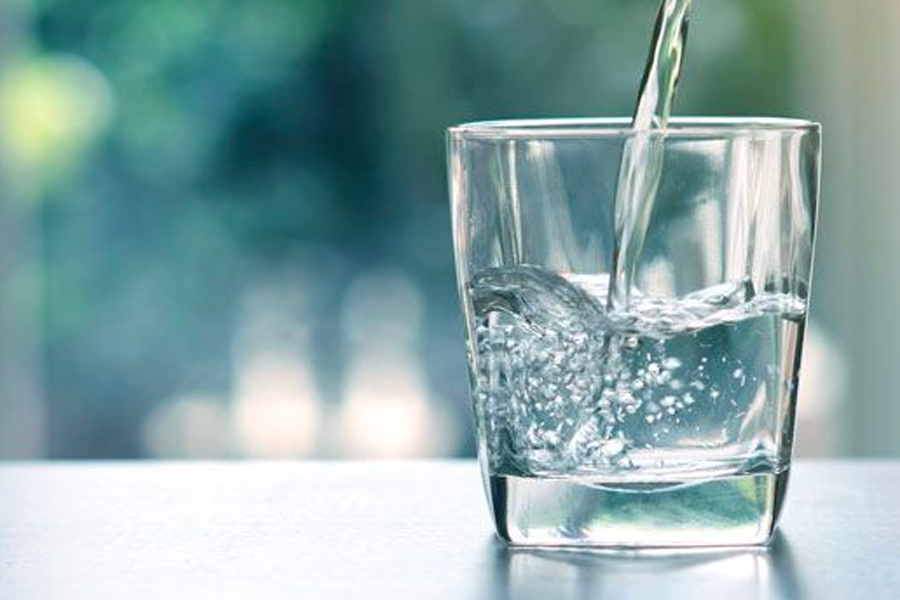 一杯透明玻璃杯中的水,建议旅行者在飞行中多喝水以适应时差。