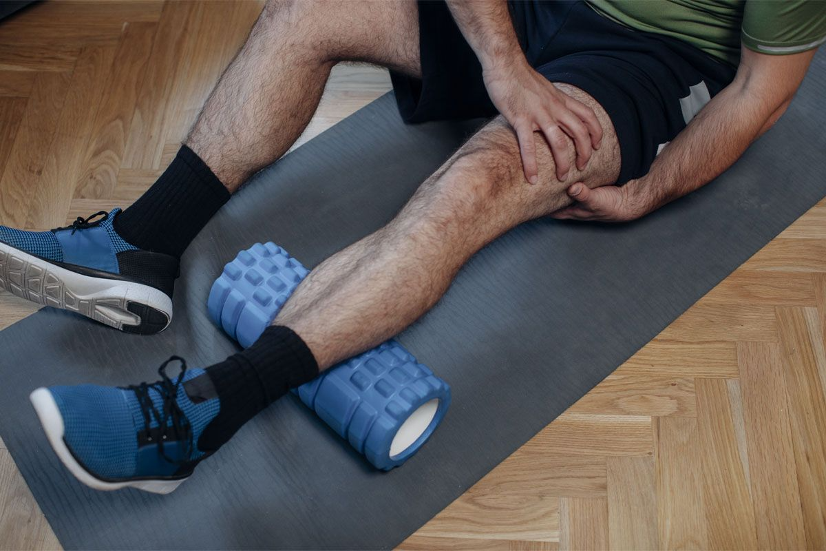 足をストレッチする男性。筋肉痛のイメージ画像。