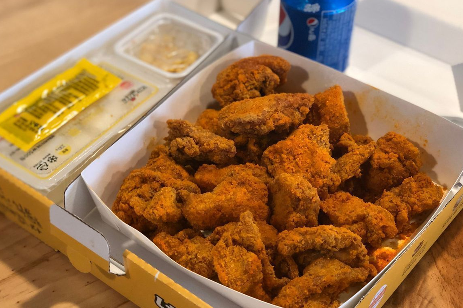 内内炸鸡的一盒快速便当,里面满满的炸鸡搭配经典的韩国泡菜,适合午餐或晚餐享用。