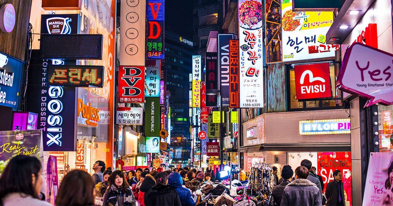 韓國首爾購物街的夜景，商店招牌亮如白晝的繁華景象。