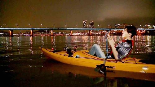 Ca sĩ Henry đang  chèo thuyền Kayak trên sông Hàn 