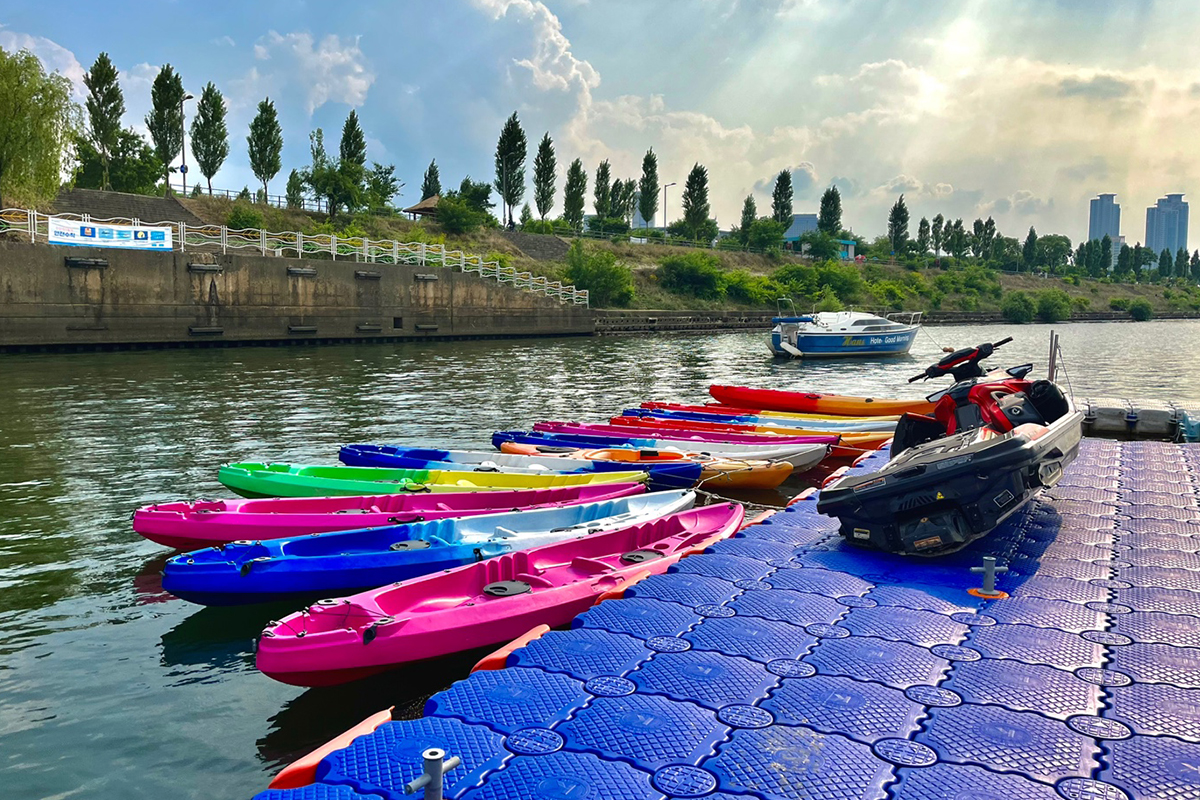 Farbenfrohe Kajaks, die im Hangang Park für ein unvergessliches Wassererlebnis angeordnet sind.