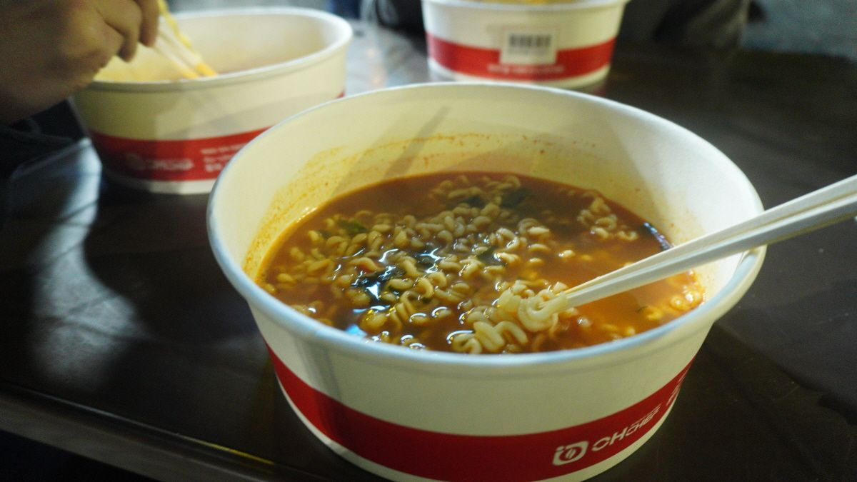 熱氣騰騰的速食拉麵置於桌上，適合在漢江邊享受美食的氛圍。