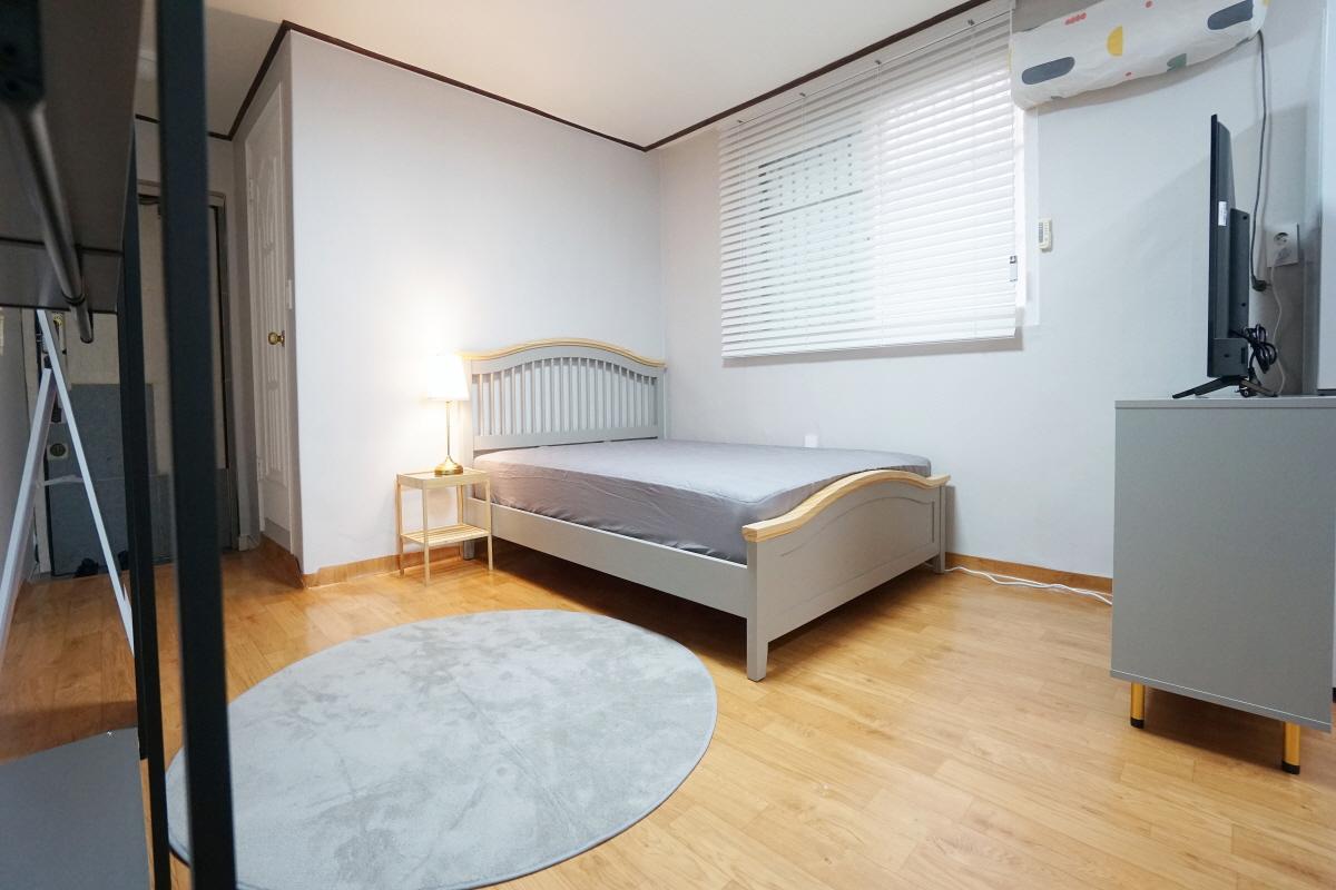 ภาพห้องนอนแบบโมเดิร์นในย่านฮงแด, โซล เกาหลีใต้ พร้อมเตียงขนาดใหญ่.