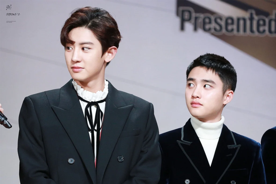 兩個身穿西裝的韓國男明星在一個活動中，其中一人較高，另一人稍矮。