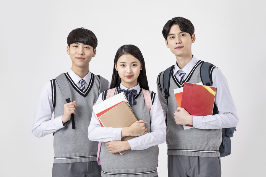 三個高中生穿著校服拿著書本，他們似乎是學生，正在準備上學或放學後的活動。
