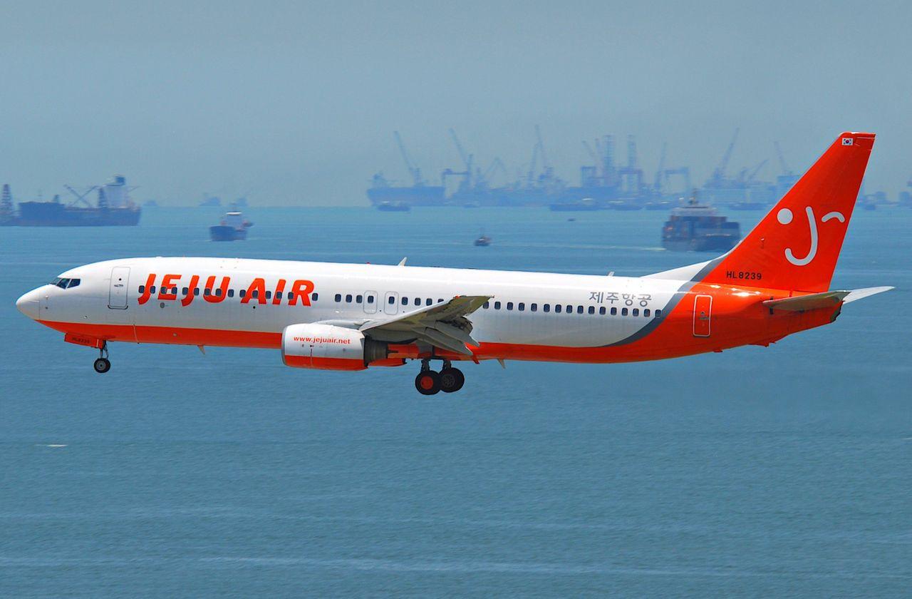 Un avion Jeju Air, modèle Boeing 737-800, sur le point d'atterrir, signifiant la connexion aérienne entre Jeju et Bangkok via Creatrip.
