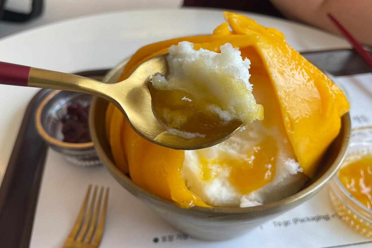 Saus mangga dituangkan di atas Real Mango Bingsu untuk menonjolkan kemanisannya, Cafe de Paris, Myeongdong.