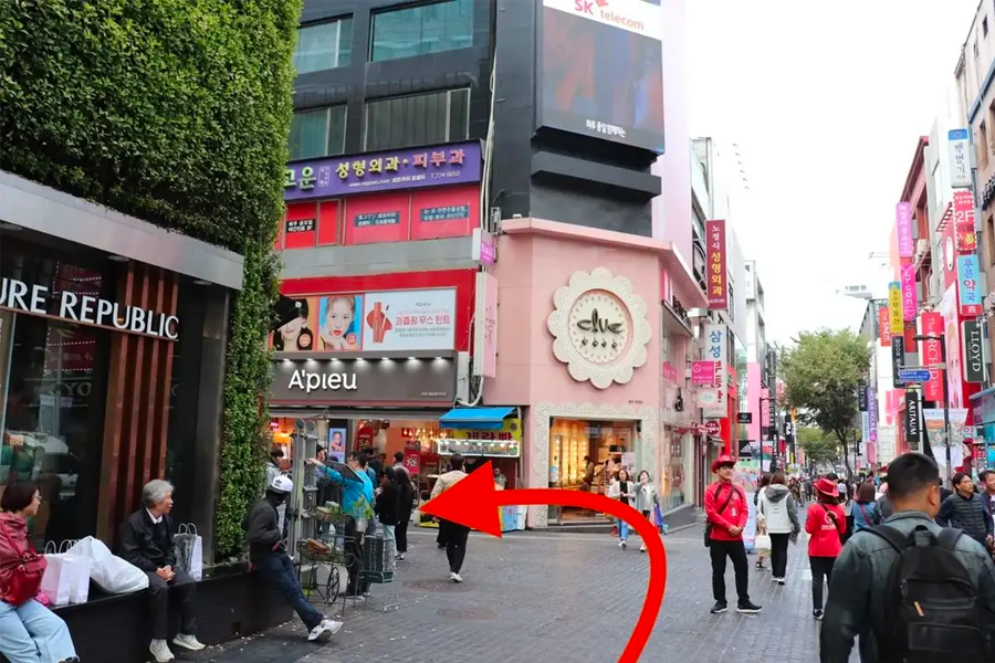 명동 거리의 모습으로, 여러 패션 상점들이 줄지어 있는 모습을 볼 수 있습니다.