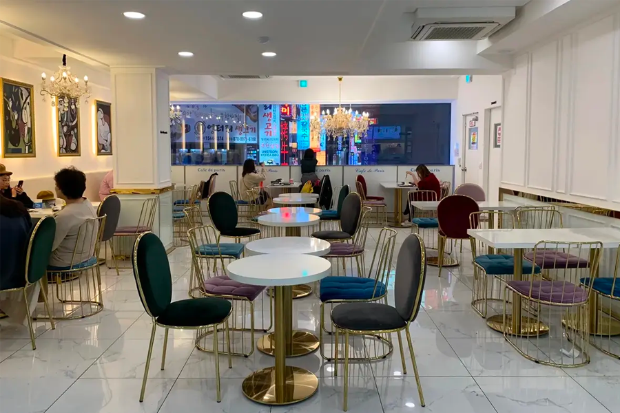 카페 드 파리의 메인 좌석 공간으로, 여러 고객들이 앉아 있는 모습입니다.