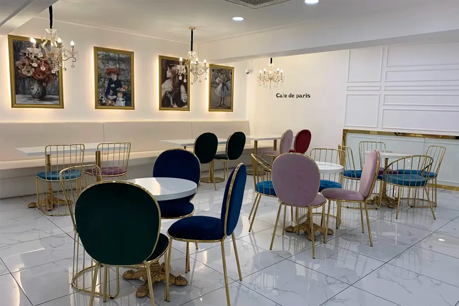 카페 드 파리 내부의 좌석 배치로, 고급스러운 인테리어와 다양한 색상의 의자들이 있는 모습입니다.
