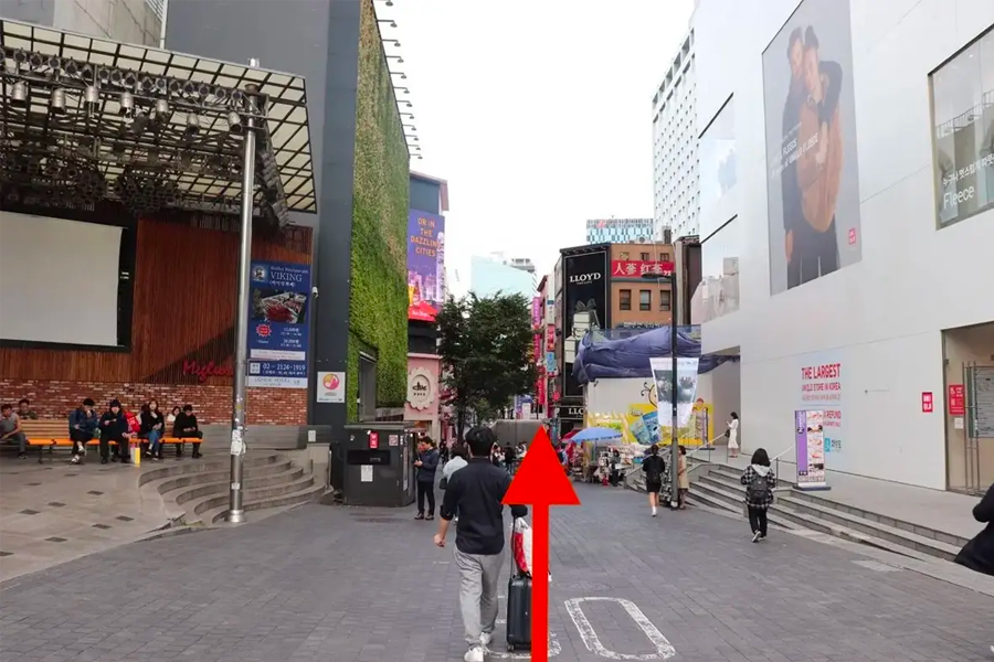 명동 거리에서의 회전 지시를 보여주는 이미지로, 커브를 돌아야 할 지점을 안내합니다.