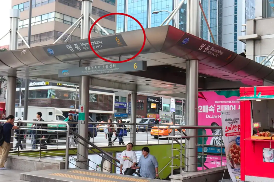 명동 거리의 모습으로, 사람들이 다양한 상점들을 지나가고 있습니다.