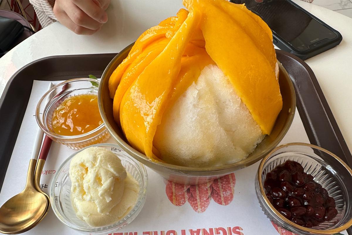 Real Mango Bingsu dengan es serut yang terlihat setelah mangga diangkat, di Cafe de Paris, Myeongdong.