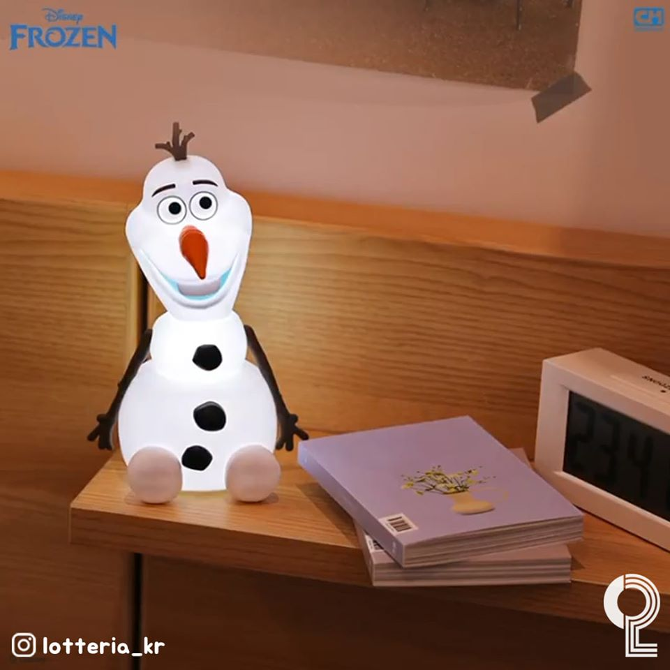 Lotteria推出的雪寶造型小夜燈，擺放在木製傢俱上，旁邊有一些書本和鬧鐘。