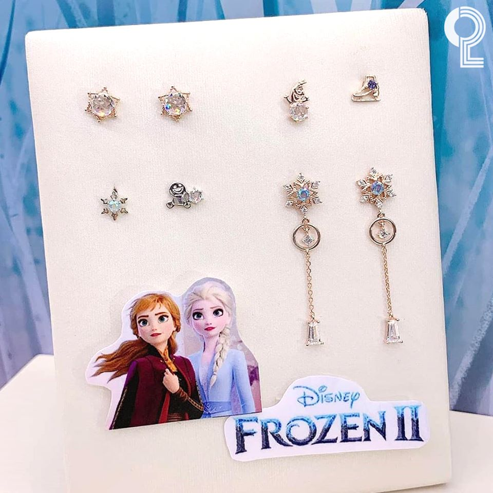 在白色展示板上的《冰雪奇緣2》耳環，設計元素包含雪寶和其他冰雪元素。