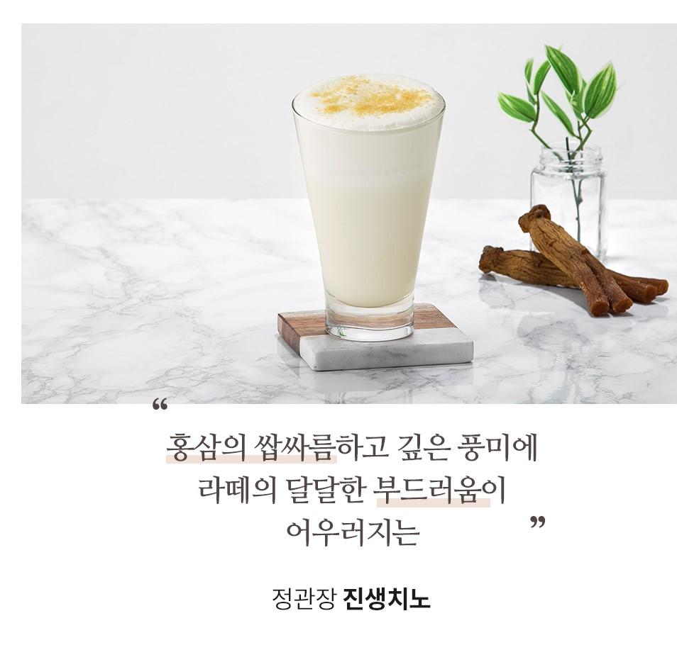 一杯奶泡丰富的人参拿铁，旁边配有红参装饰。