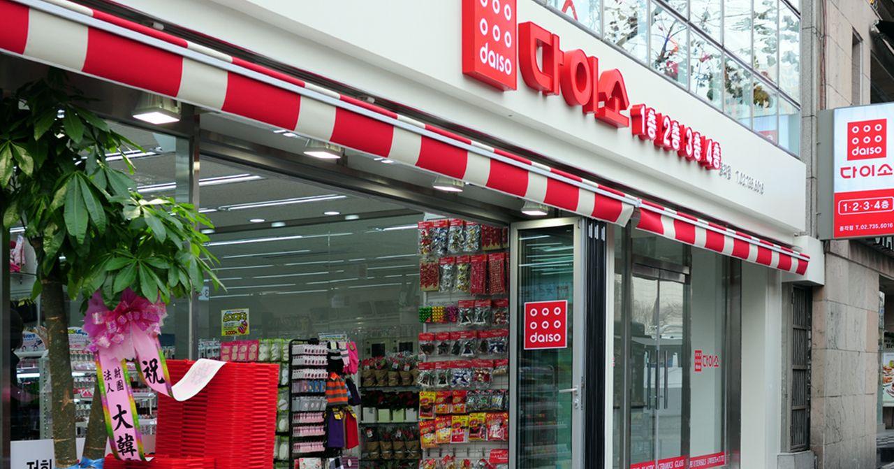 明亮的韓國大創分店外觀，用紅白相間的標誌和裝飾營造招牌店面。