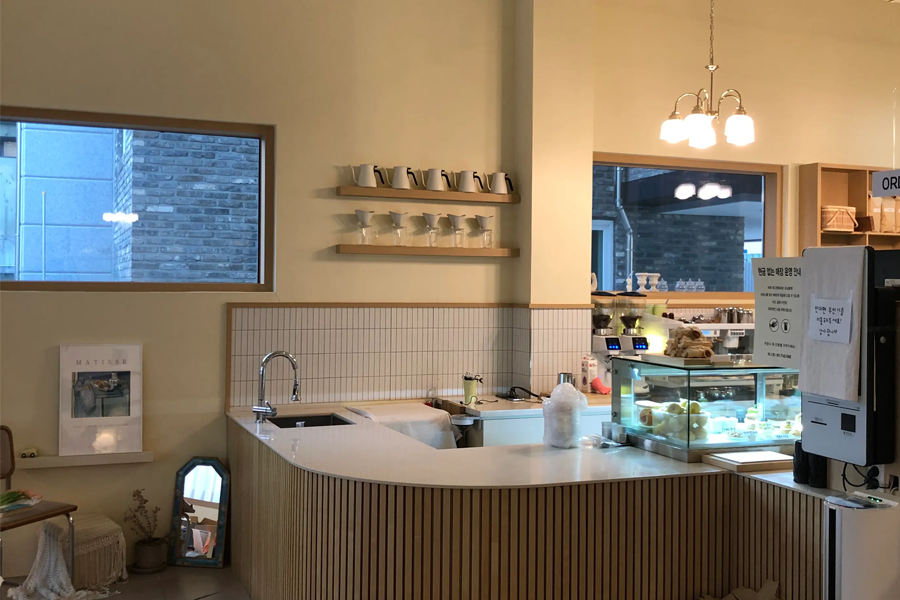 Tag One咖啡厅内部的细节，有柜台和展示柜的区域，现代又简约的设计