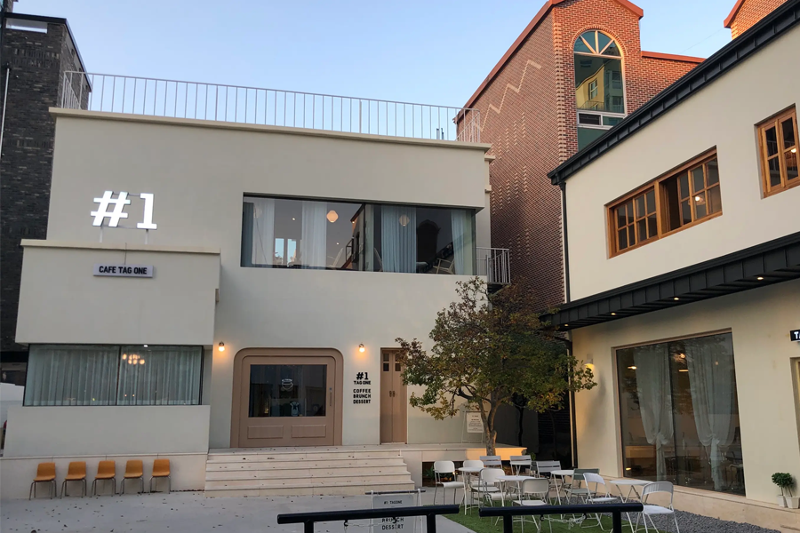 清州Tag One咖啡厅的外观，建筑风格现代，背景为清晨或傍晚的天空