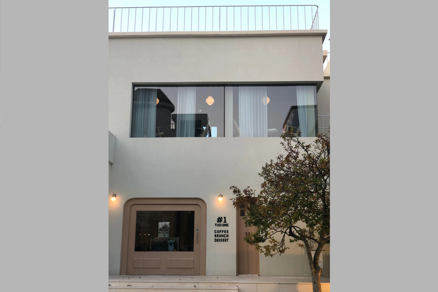 清州Tag One咖啡厅的外观近景，展示了二楼的大窗户和入口处