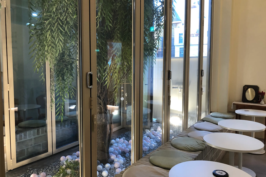 Tag One咖啡厅的靠窗休闲区，有舒适的座椅和柔和的采光