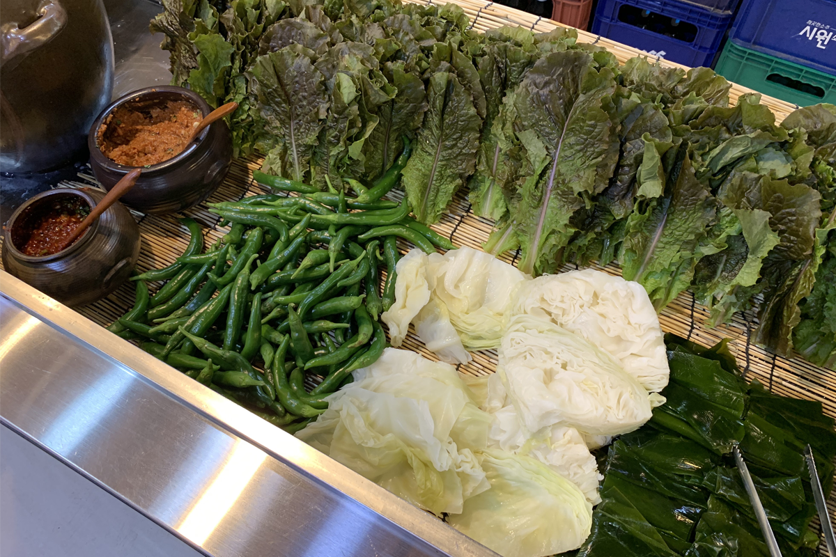 豆田里餐厅供应的新鲜生菜区，包括生菜、辣椒和泡菜，供客人搭配主餐享用。