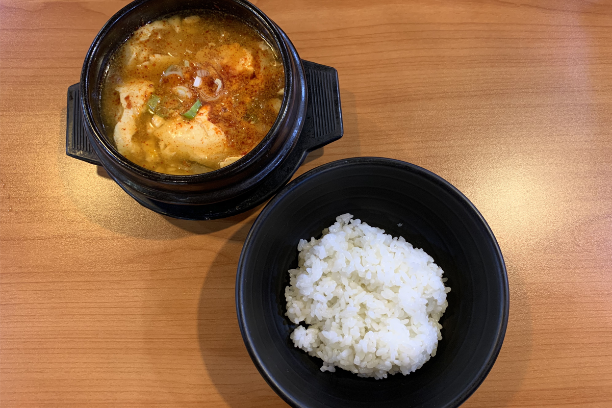 豆田里的两份不同主菜：豆腐锅和豆腐渣汤，分别搭配两碗白米饭。