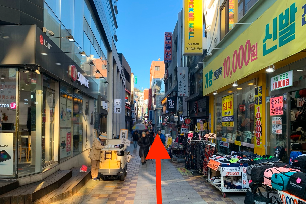 釜山南浦洞CLUBCLIO店前的街道，附近有雜貨攤和人羣。