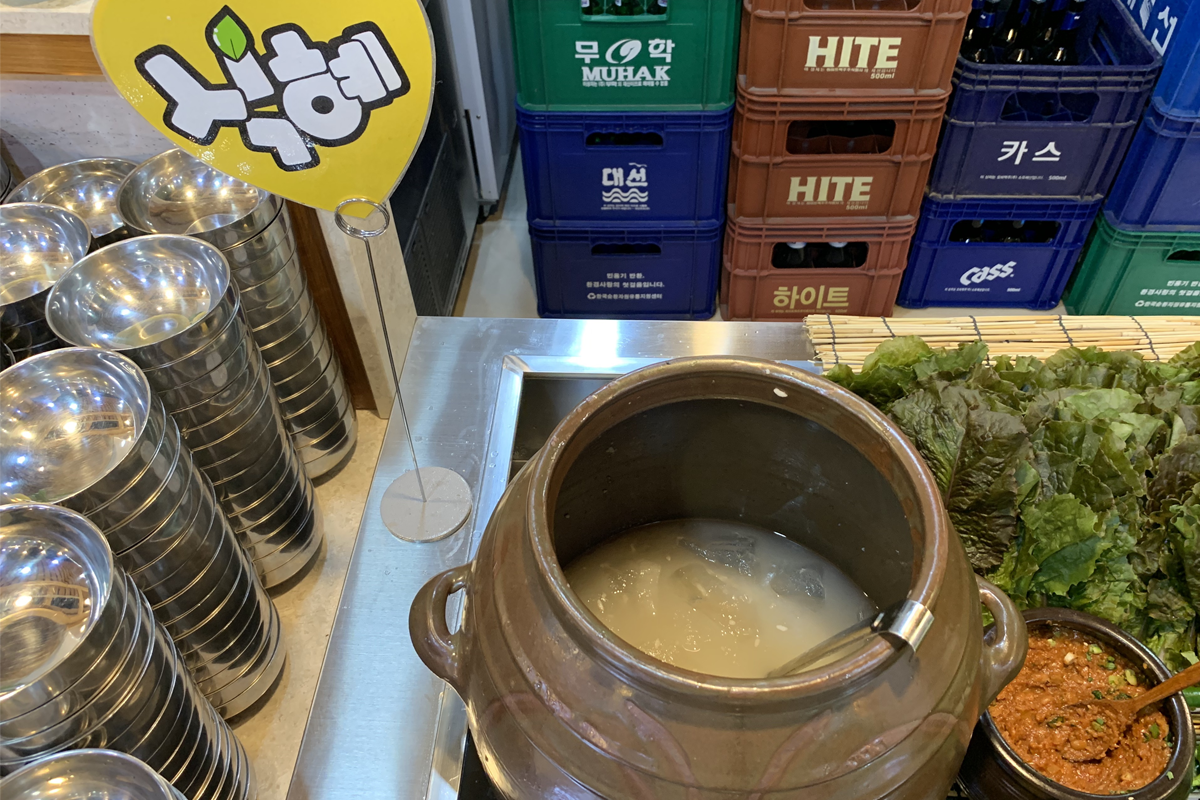 豆田里自助餐区特别提供的一种甜米酿饮料，展示在陶器中，供客人自由选取。