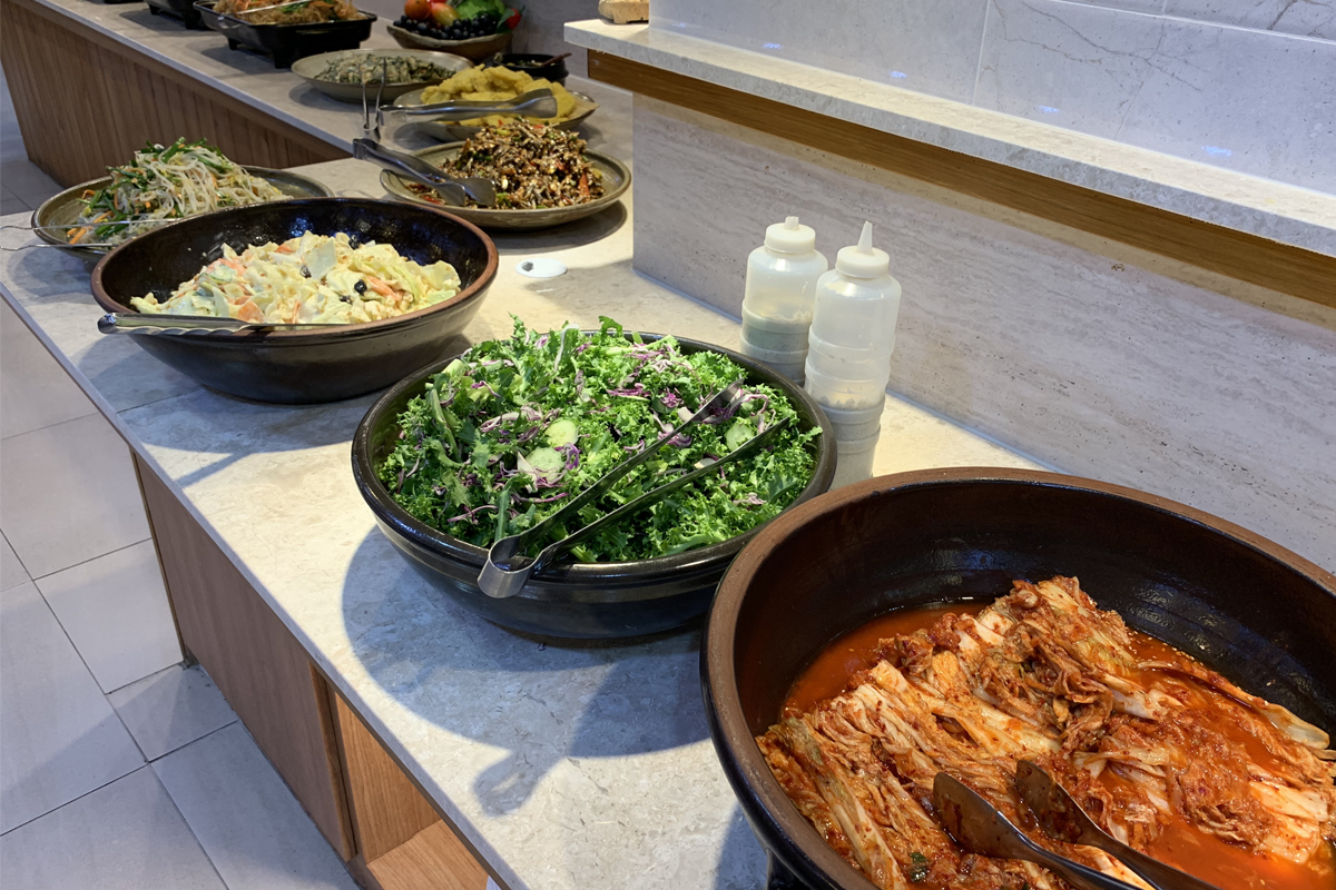 豆田里自助餐区的一部分，展示各种新鲜蔬菜沙拉、泡菜和其他韩式开胃菜。