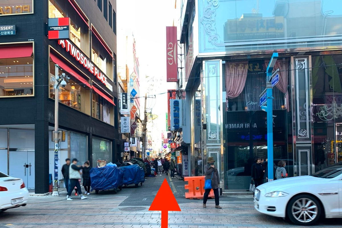 位於釜山的Hello？商標附近的購物街街景，展示多家店舖和攤位。