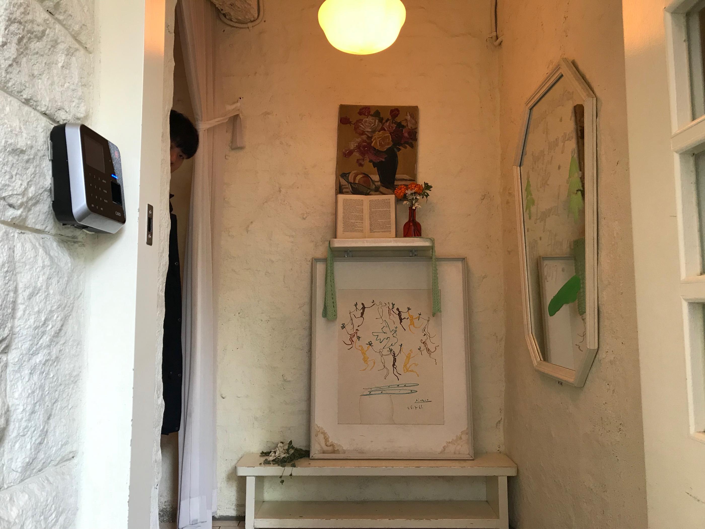 ทางเข้าของ Cafe Layered ตกแต่งด้วยภาพศิลปะและของวินเทจสร้างบรรยากาศอบอุ่น