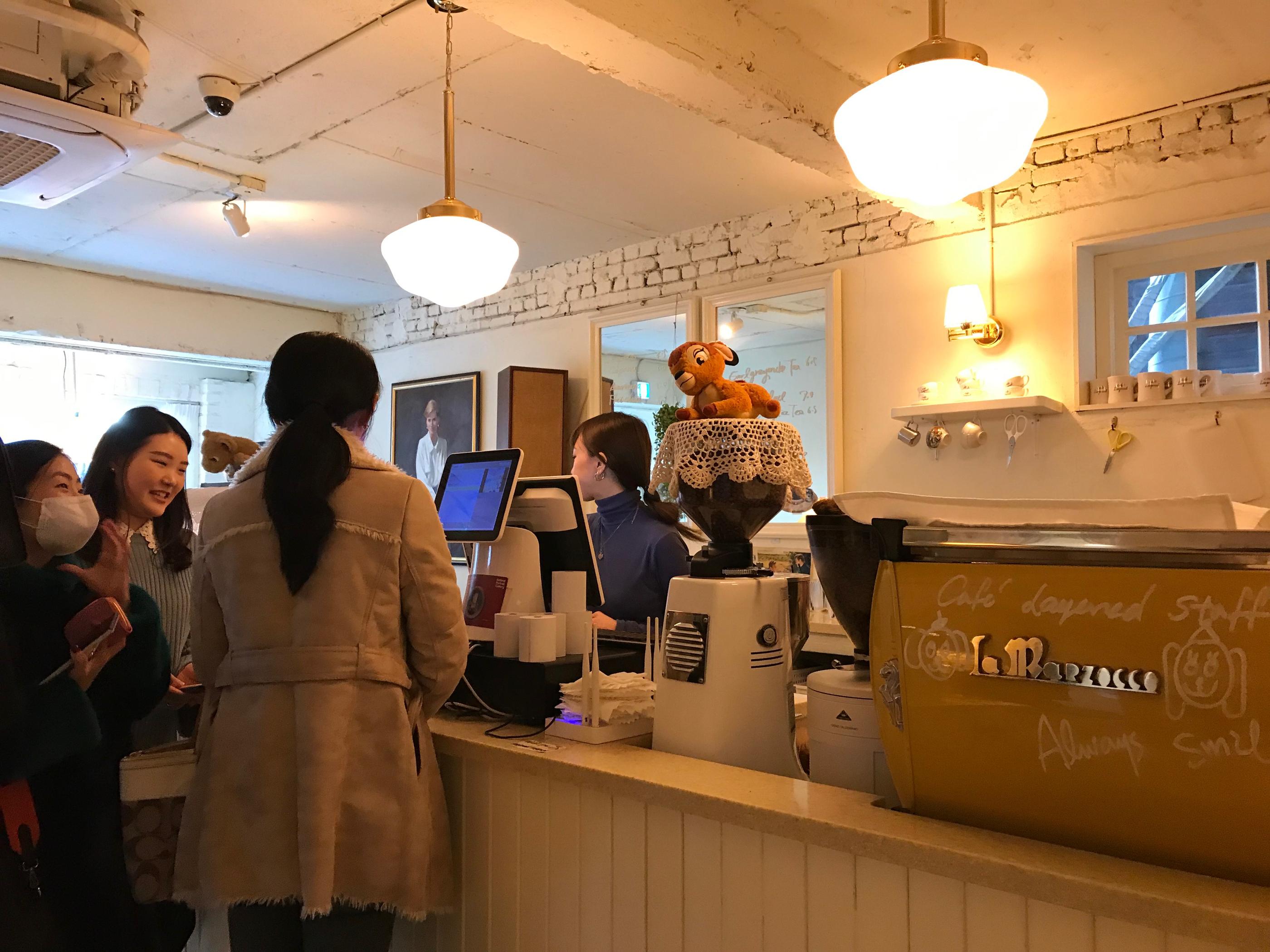 บรรยากาศภายใน Cafe Layered แสดงเคาน์เตอร์สั่งเครื่องดื่ม มีการตกแต่งที่น่ารักในสไตล์อังกฤษ