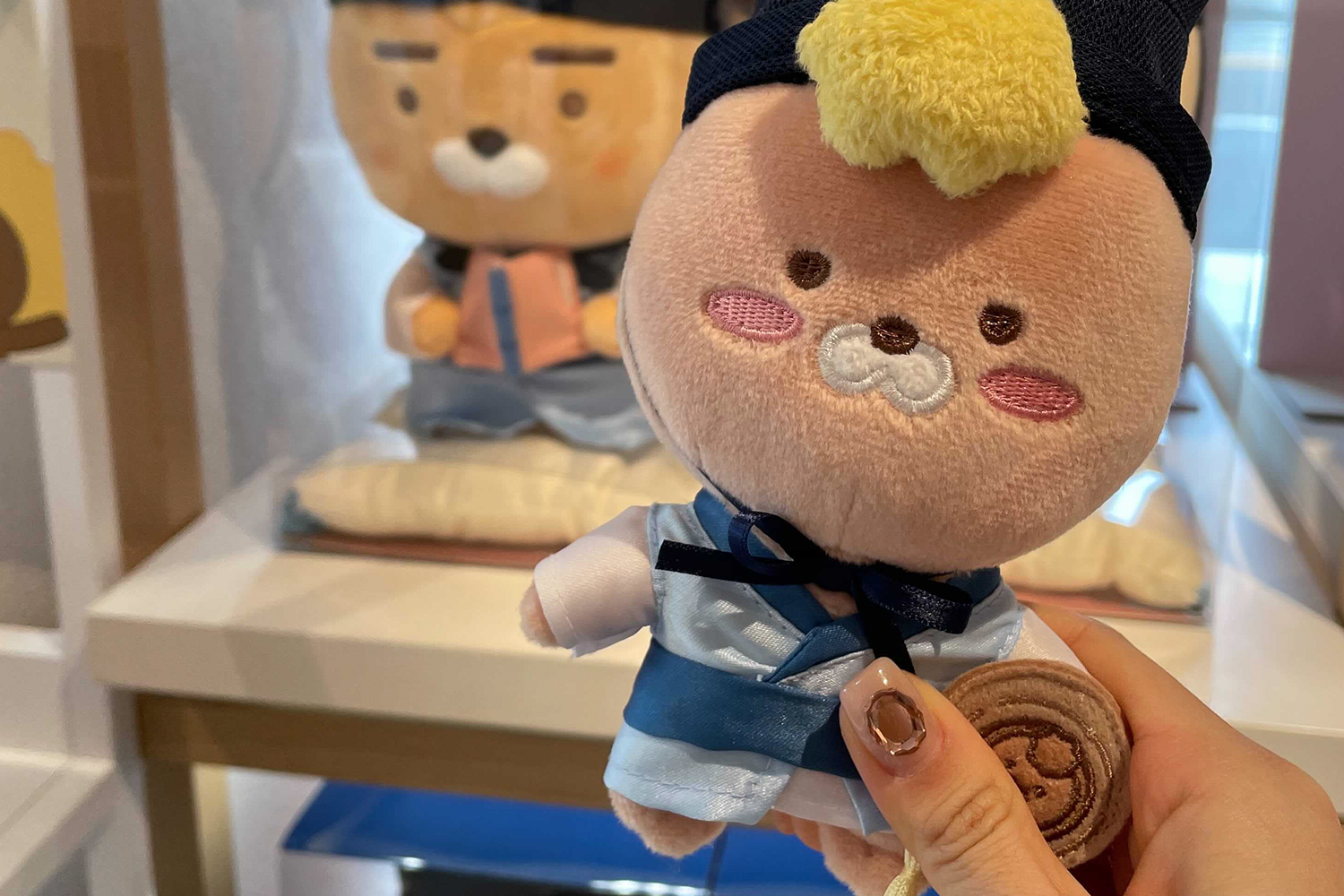 手持著韓服造型小Ryan娃娃，展現出可愛手作風，透過小巧造型突顯全州Kakao Friends的手工設計細節。