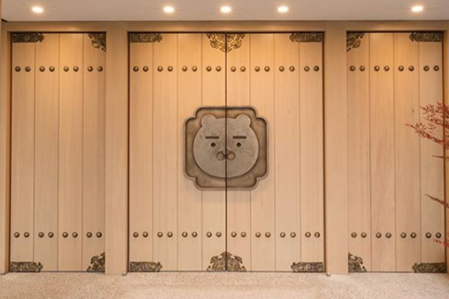 全州Kakao Friends商店的入口，呈現傳統韓屋風格的大門上刻有可愛的Ryan臉龐裝飾，營造出獨特的視覺風格。