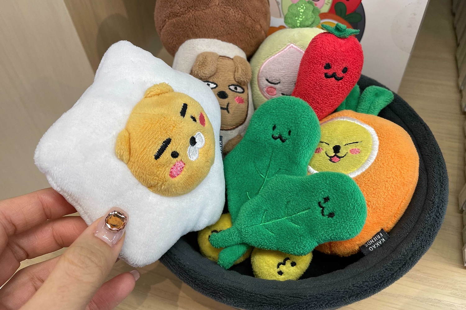 顧客於全州Kakao Friends商店手捧可愛的韓國料理造型布玩偶，充分體現商品的地方特色和創意設計。
