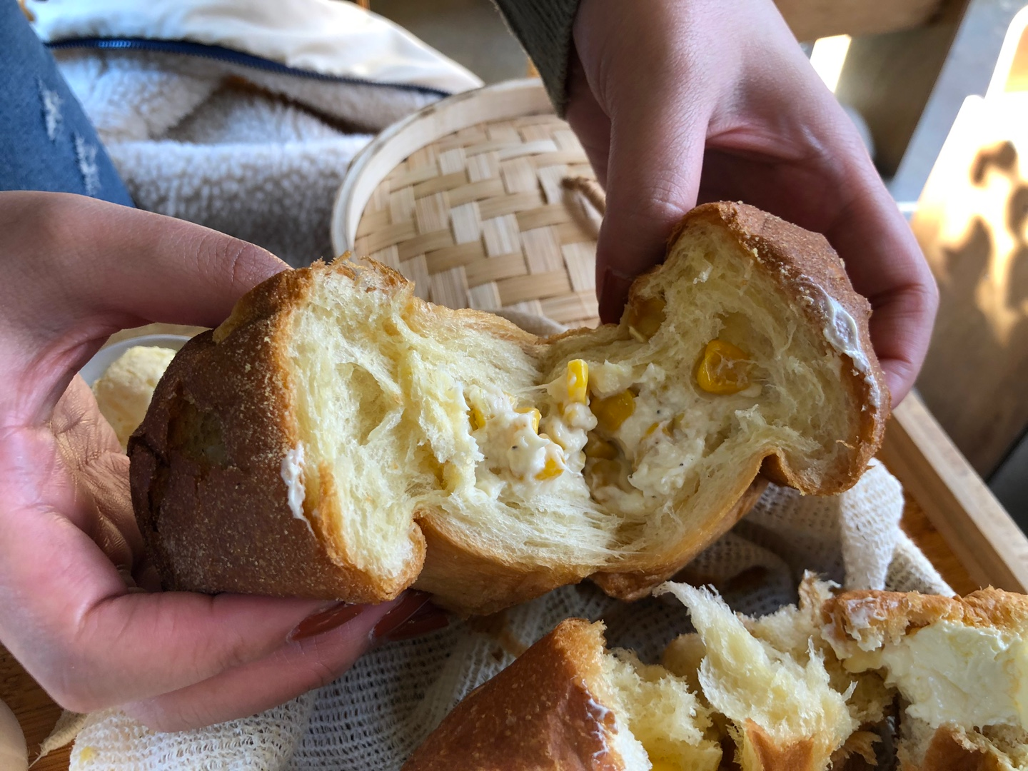 MIL Toast House에서 제공되는 옥수수맛 스팀 토스트, 방문자가 손으로 토스트 속을 보여주는 모습