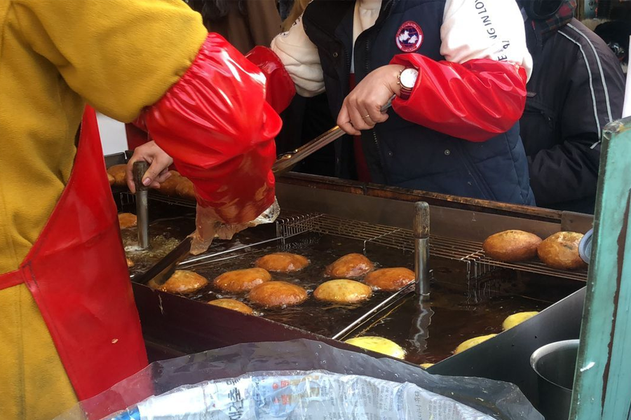在韓國街頭攤販製作中的糖餅（호떡），這是深受歡迎的韓國甜食，尤其在冬季暖胃，是小編極力推薦一試的便宜美食。