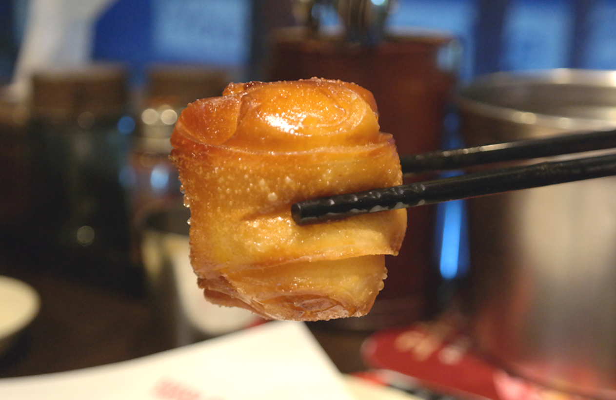 ホアジュアン（中華風蒸しパン）を箸でつかんだ様子