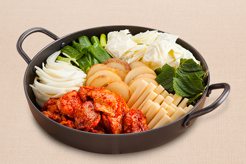 白鐵盤餐廳中的招牌辣炒雞排,盤中滿滿的食材包括泡菜、馬鈴薯、年糕等。