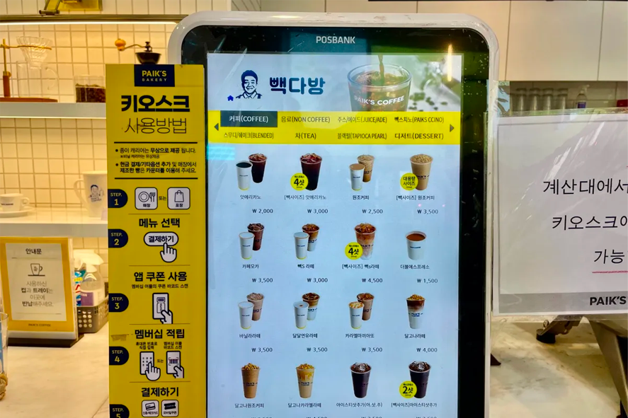 Paik's Coffee店內的飲品販售機,列出各類咖啡、茶和冰沙的詳細價格和選項。