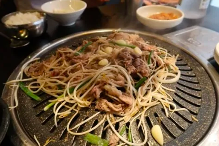 石拜基家烤肉店內豆芽炒肉片,放在烤盤上的香辣韓式烤肉,充滿香氣。