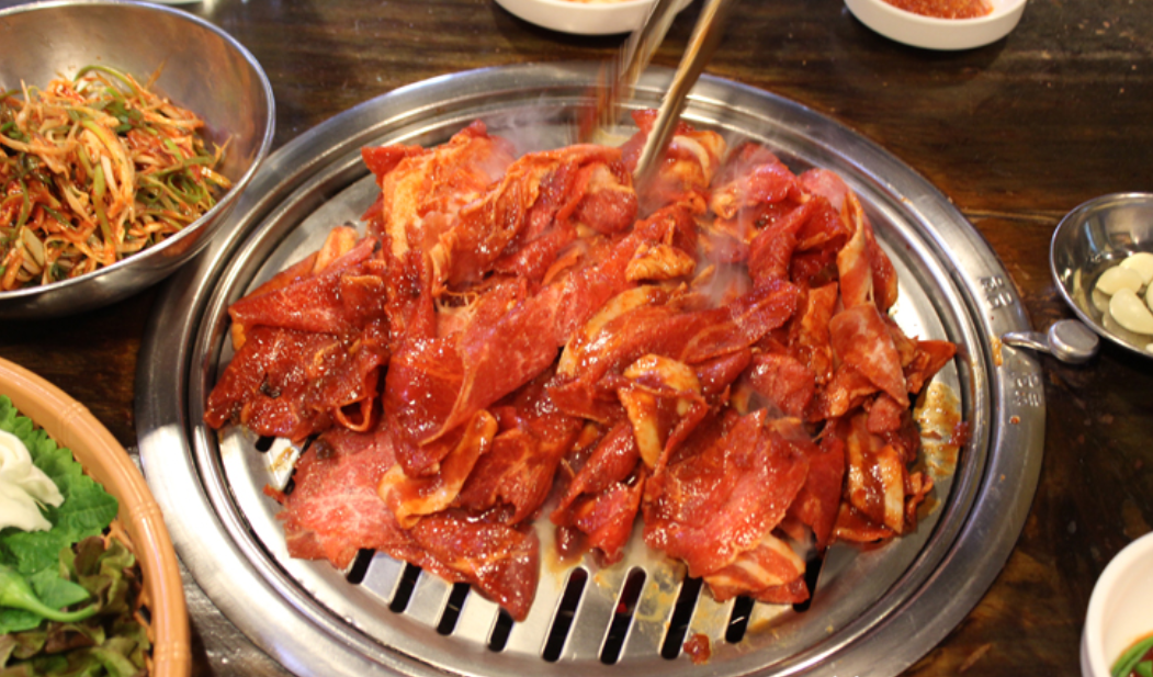 焼肉がグリルで焼かれている様子