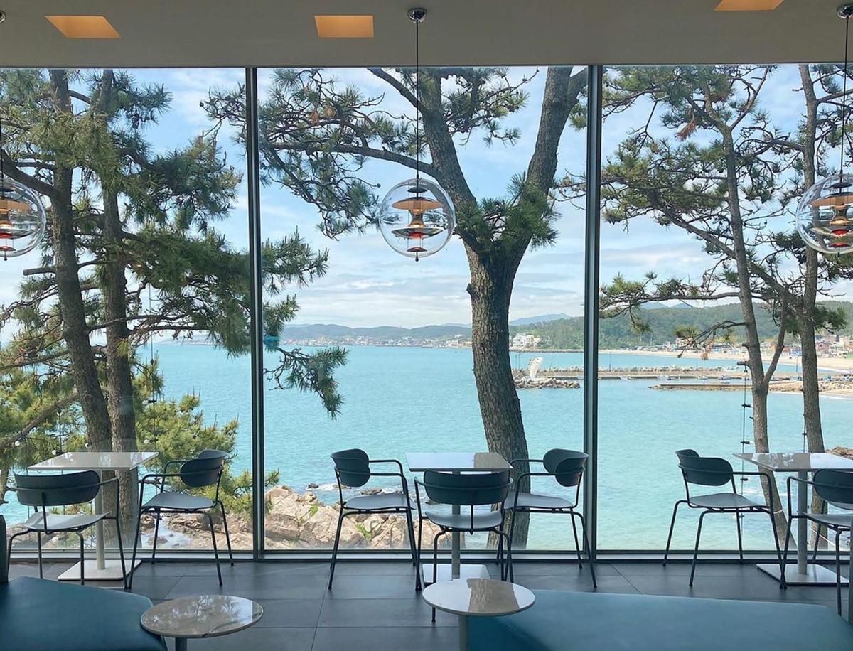 Offizielles Instagram-Foto von Waveon Coffee mit Meerblick durch große Fenster