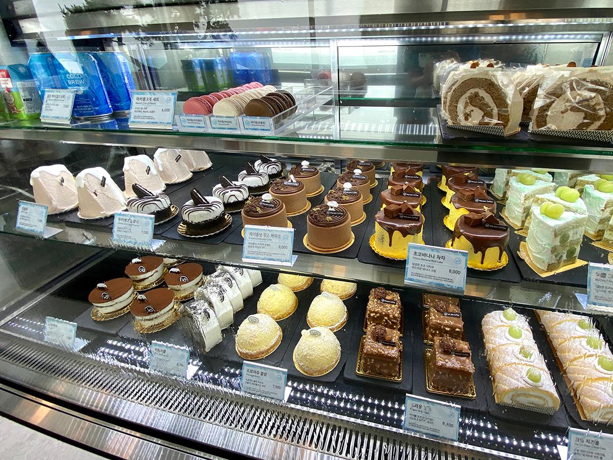 Kuchen und Gebäcksortiment in einer Vitrine bei Waveon Coffee