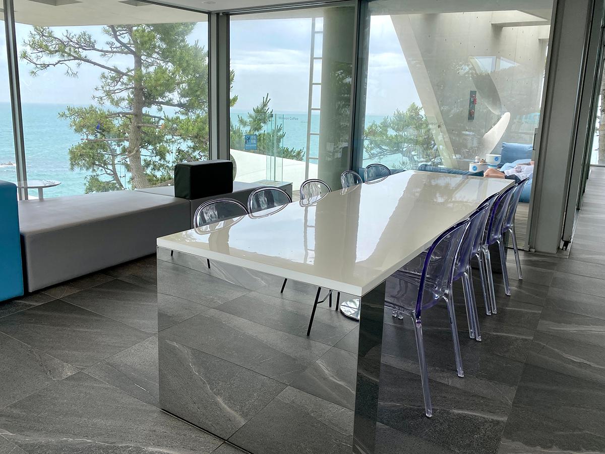 Großer Tisch für Gruppen im Innenbereich des Waveon Coffee mit Meerblick