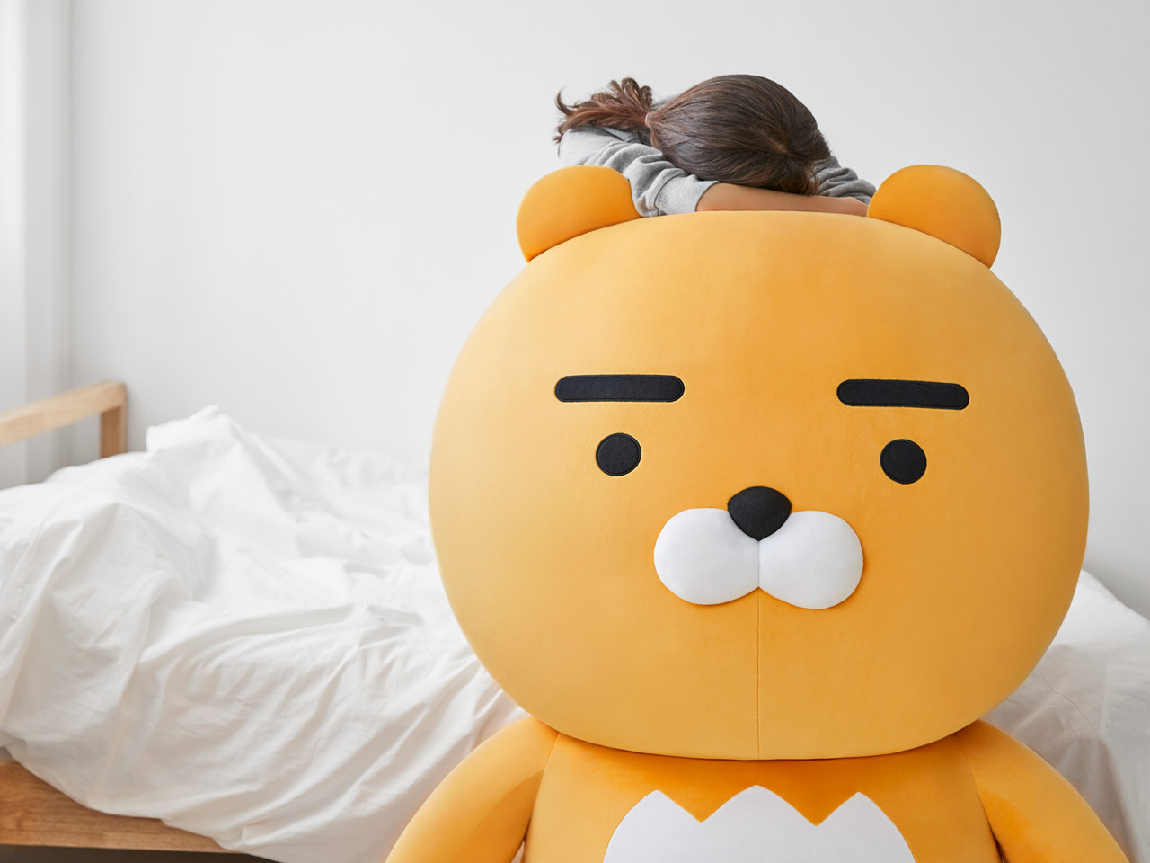 巨型 Ryan 布偶的特寫畫面，展示其標誌性的粗眉毛和治癒微笑，成為家庭中的溫暖陪伴。