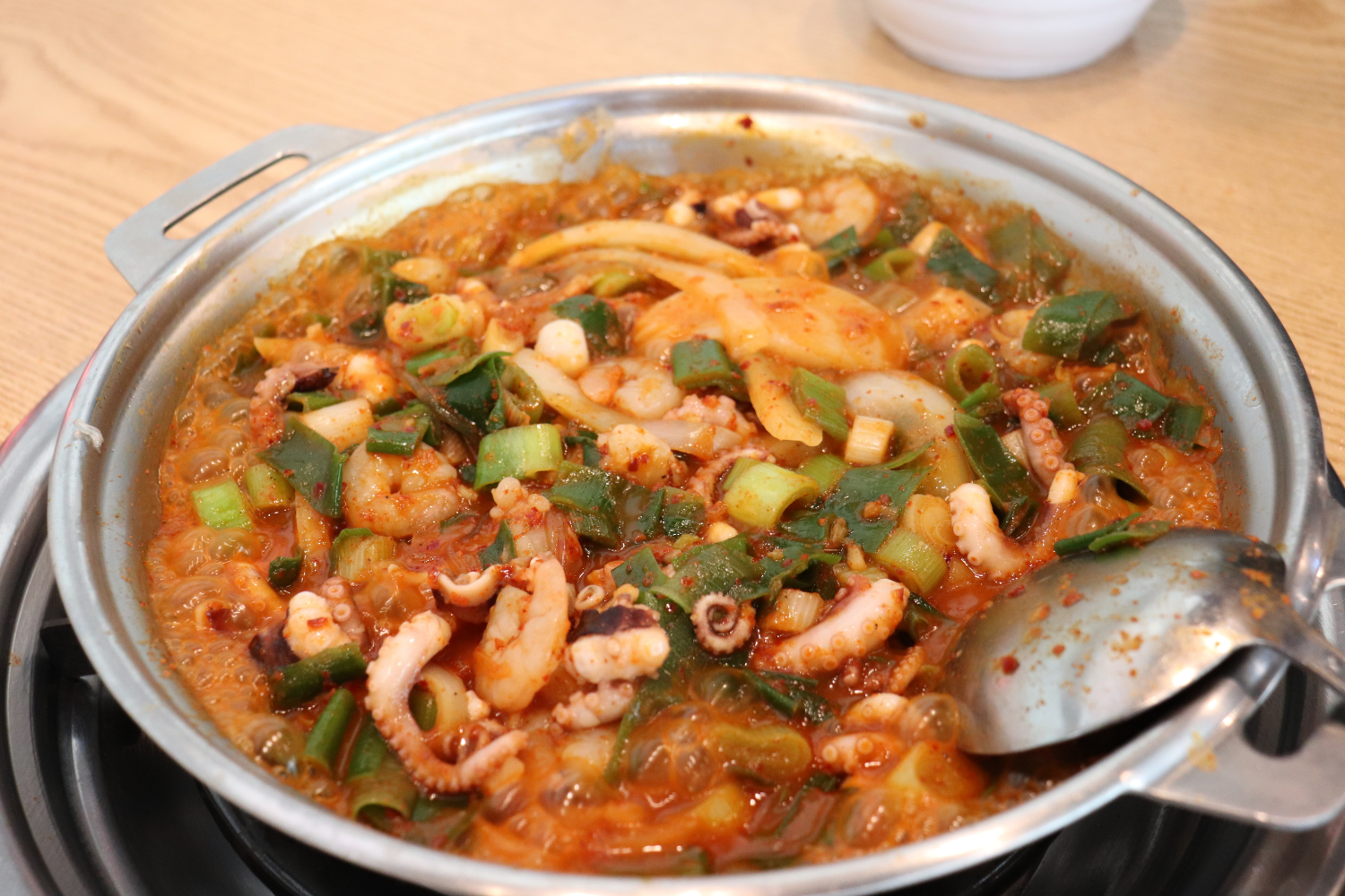 香辣白歲章魚韓式鍋，內含多樣食材如章魚和蔬菜，味道豐富。