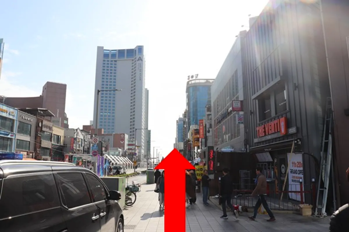 白天海雲臺街道，記標紅色方向箭頭指引至百歲章魚餐廳的路線。